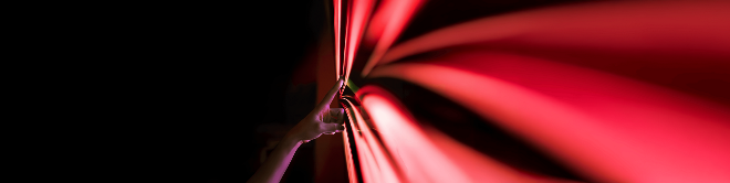 A hand touching PHINIA's red arrow logo